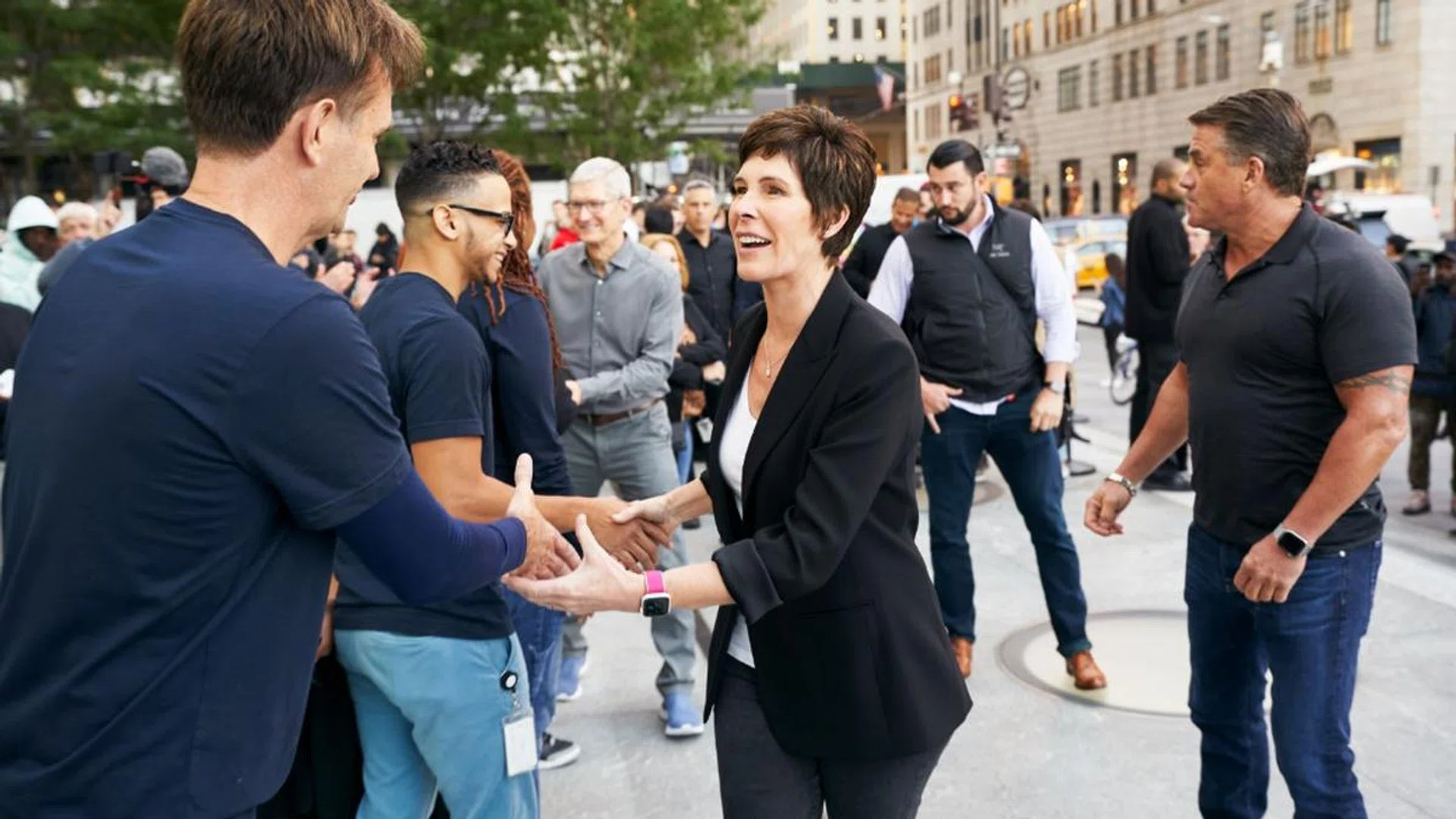Dierdre O'Brien and Tim Cook greet employees at an Apple store in the US.