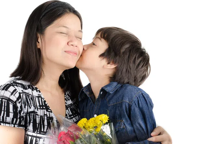 39294406 - little boy kissing his mother with flower on white background