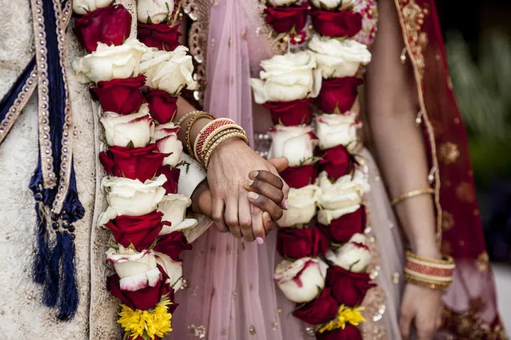 Detail of hands and clothing during Indian wedding ceremony.