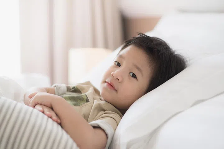 Cute asian child lying on white bed
