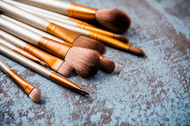 Professional makeup brushes collection, new make-up tools set on painted background with copy space