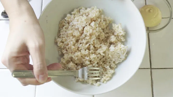 01. Break up clumps of rice with a fork. Add 1 heaped Tablespoon of Japanese mayonnaise. Mix well so mayonnaise coats each grain of rice – this trick gives fluffy Yakimeshi rice. Break big chunks of tuna into smaller pieces, so they can fry evenly.