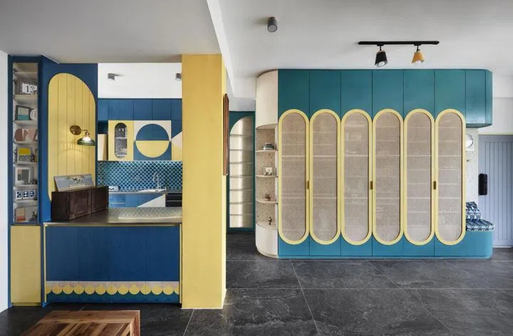 Teal and yellow shoe cabinet and settee fitted with rattan doors by the main entrance in a 2-bedroom walk-up apartment along East Coast Road.