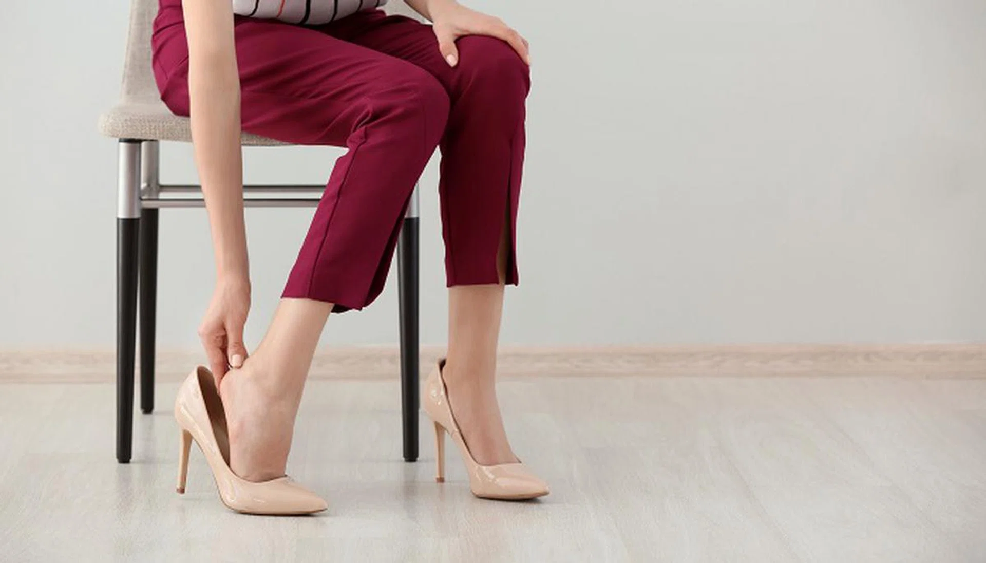 Tired young woman feeling ache in legs indoors