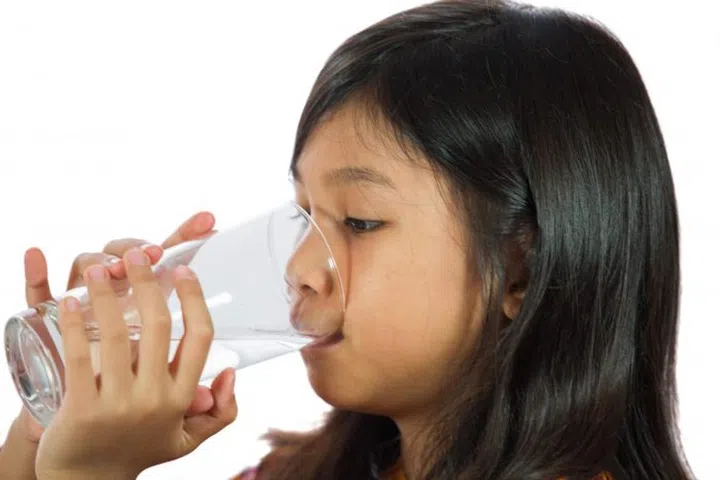 Young Malay  Asian girl drinking a glass of water