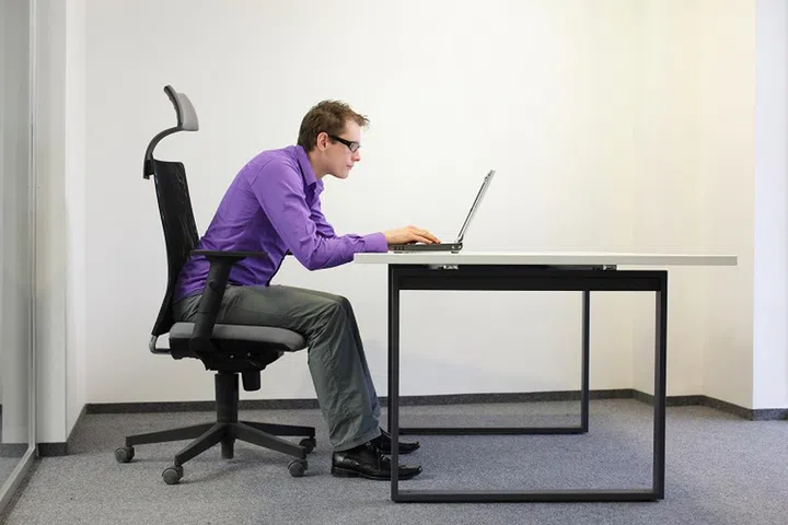 bad sitting posture at laptop . man on chair