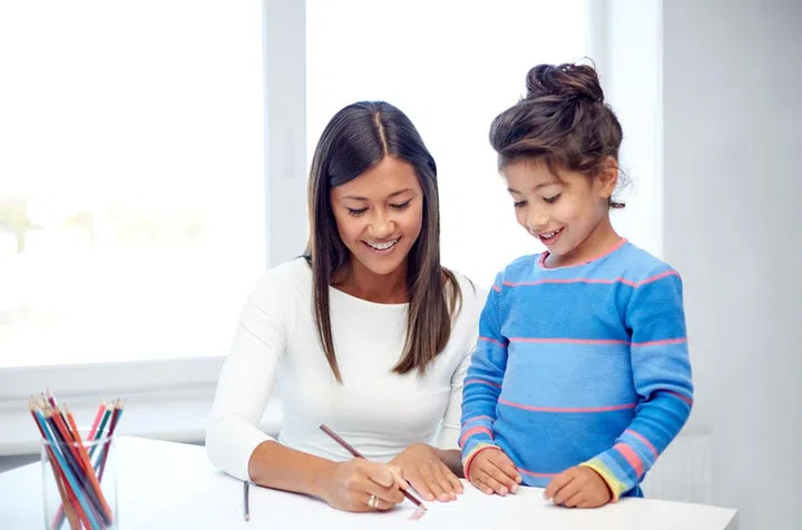 48511432 - family, children, creativity and happy people concept - happy mother and daughter drawing with pencils at home or kindergarten