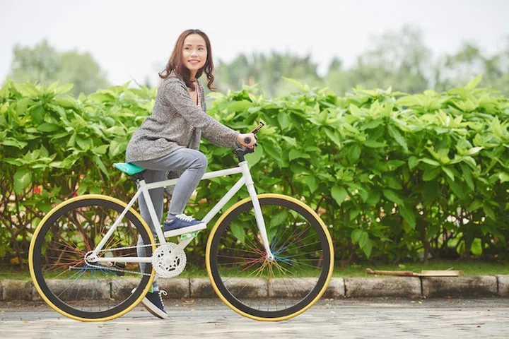 Portrait of pretty Vietnamese woman riding bicycle