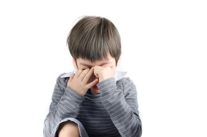 Little boy pain his eyes put finger in on white backgroud
