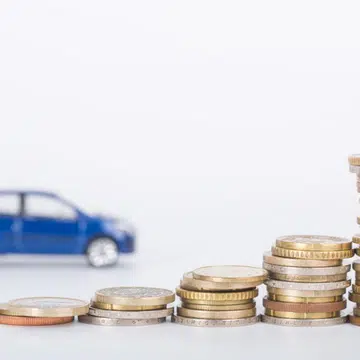 Car finance money stack with white background.