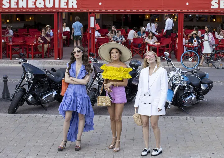 Emily in Paris. (L to R) Lily Collins as Emily, Ashley Park as Mindy, Camille Razat as Camille in episode 202 of Emily in Paris. Cr. Carole Bethuel/Netflix © 2021