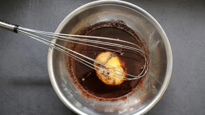 02. Remove the bowl from the fire. Add a beaten egg to the mixture and stir well.