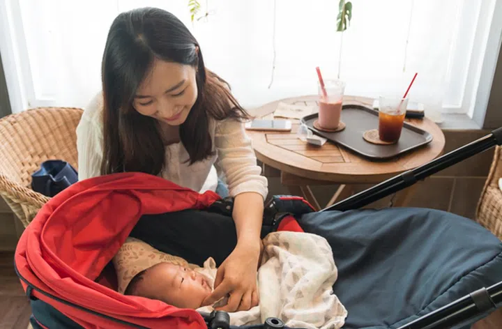 Asian young mother looking after her baby