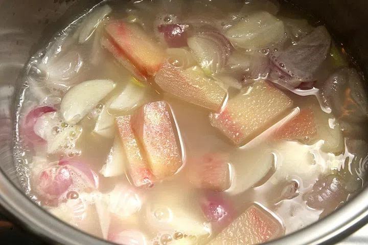 02. Put in the shallots, garlic, galangal and lemongrass and boil for 10 mins until the shallots are softened.