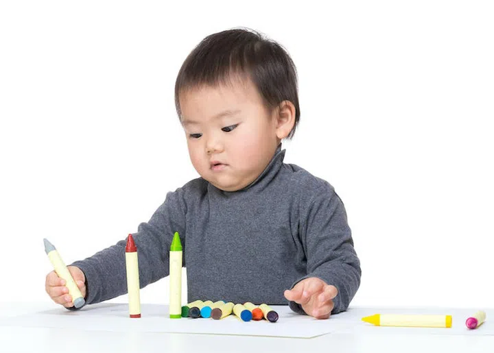 Child boy playing with crayon