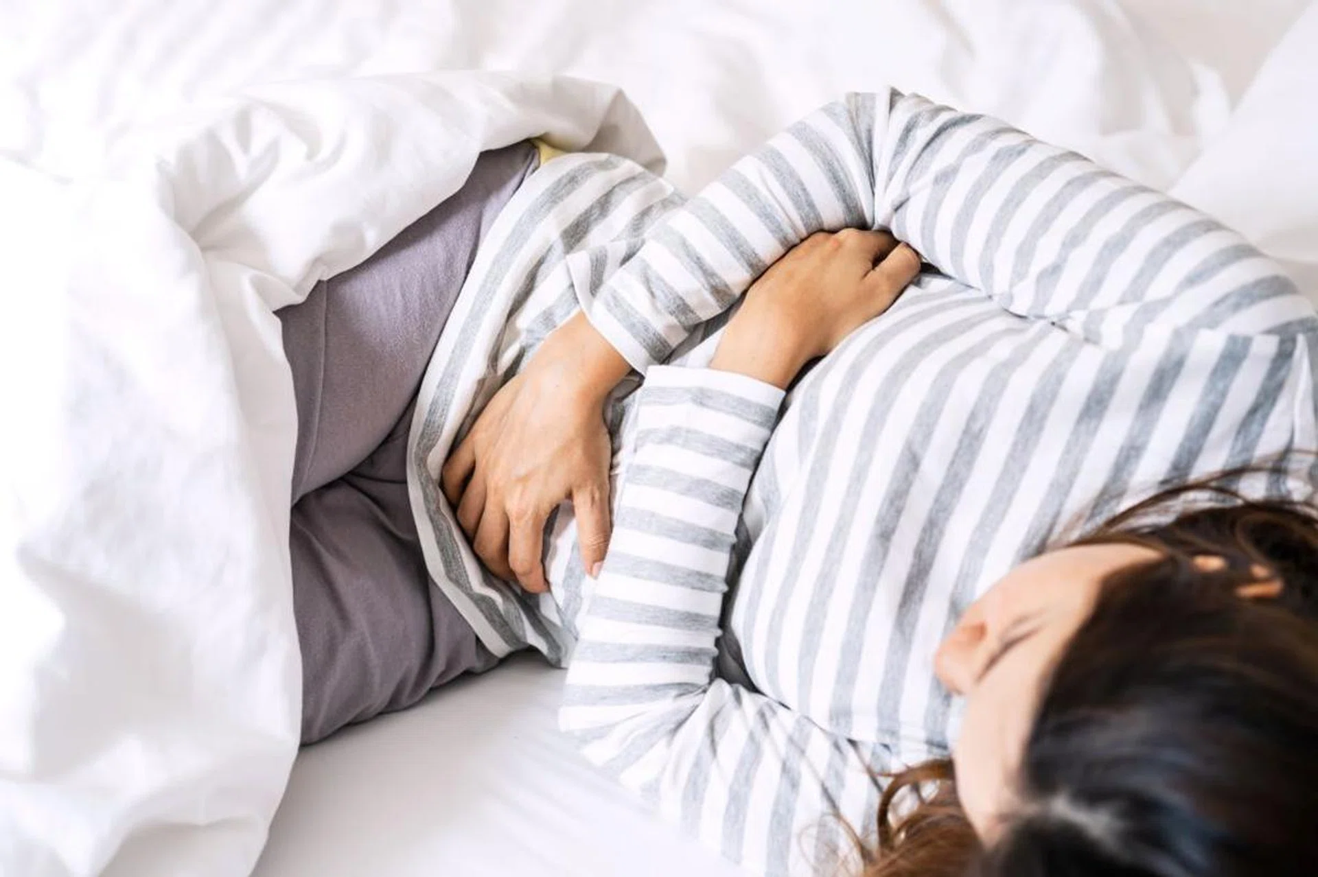 lady lying on bed in pain
