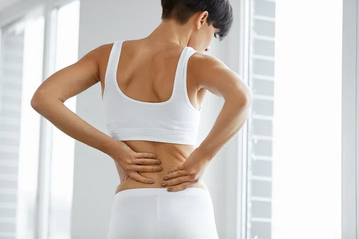 Back Pain. Closeup Of Beautiful Woman Having Spinal Or Kidney Pain, Backache. Female Suffering From Painful Feeling, Muscle Or Nerve Pain, Holding Hands On Body. Health Issue Concept. High Resolution