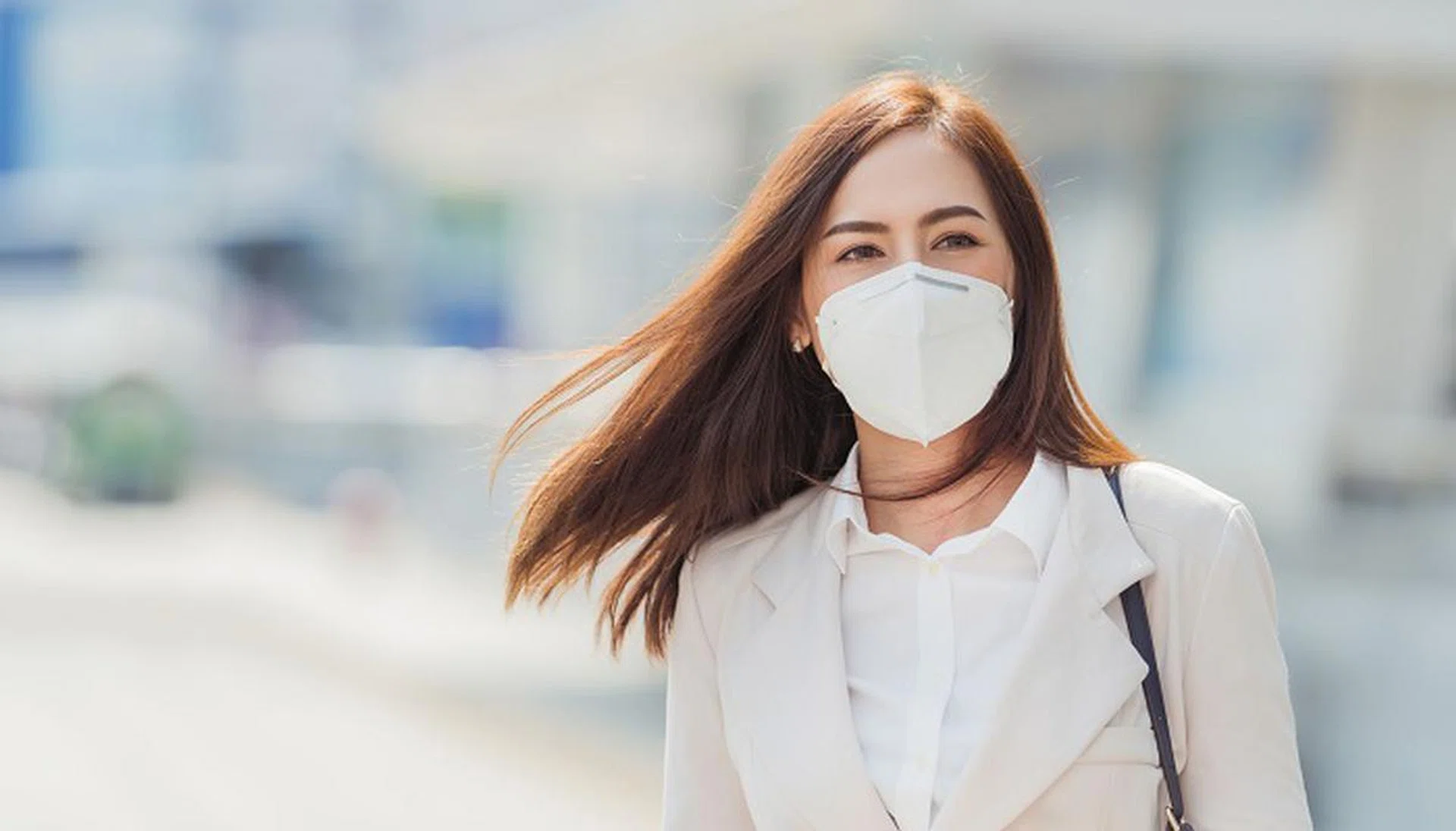Asian woman are going to work.she wears N95 mask.Prevent PM2.5 dust and smog