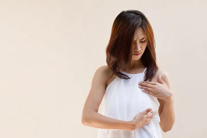 Breast Cancer woman examines her breast