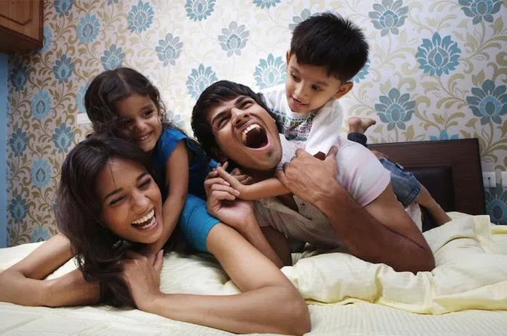 21399709 - family lying on bed smiling