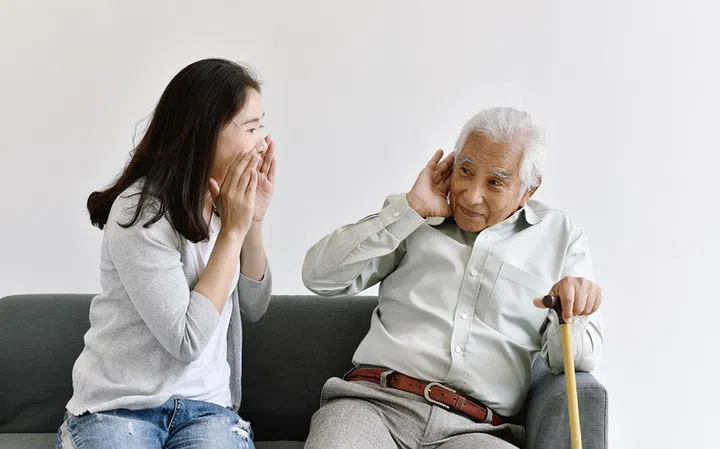 Hearing loss problem, Asian old man with hand on ear gesture trying to listen shouting woman, Aging senior decline in hearing ability, Elderly health problems concept.