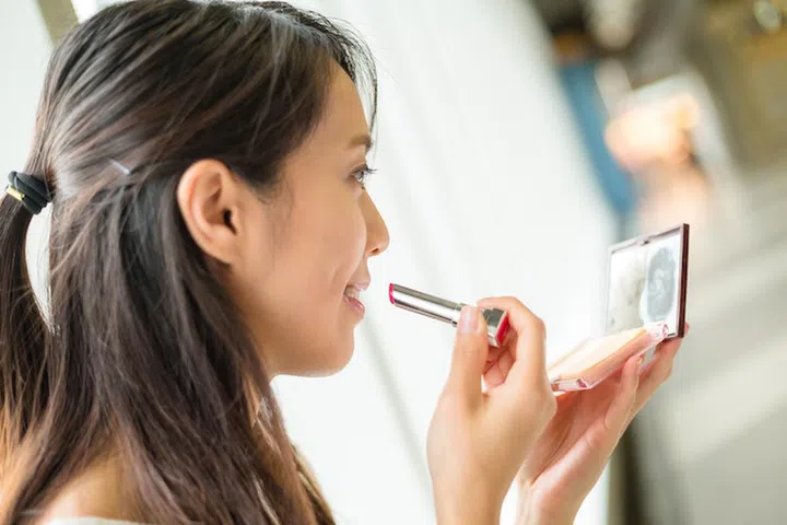 Woman apply lipstick