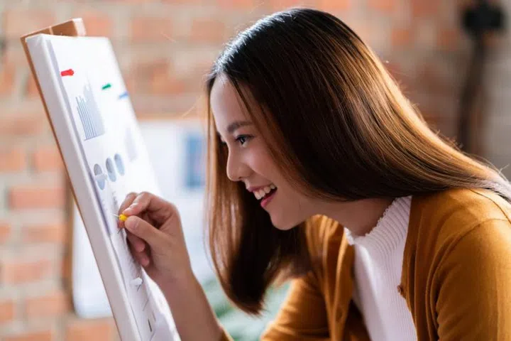 Asian business woman pinning on graph