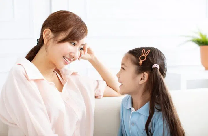 happy mother talking with  little girl  at home