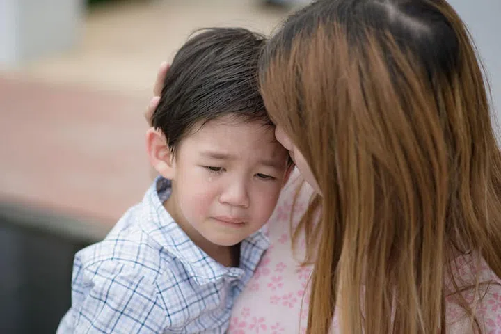 58908609 - asian mother embracing and consoling her son
