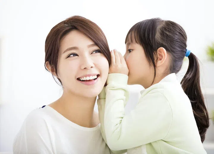 mother and daughter whispering gossip