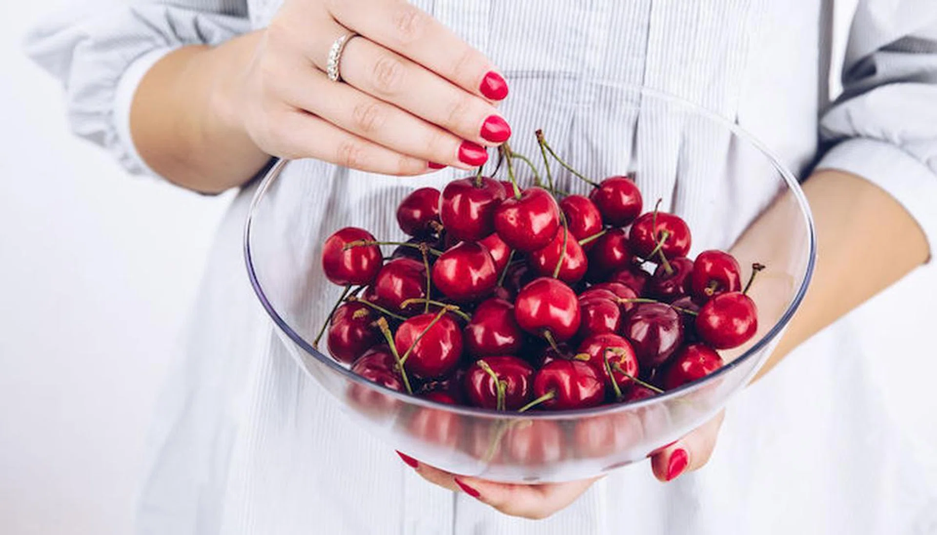 Cherries. Fresh red ripe cherry in a bowl on woman hands holding. Summer seasonal food concept