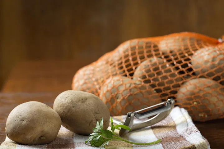 Close up of potatoes that are out of the jute bag ready to be peeled
