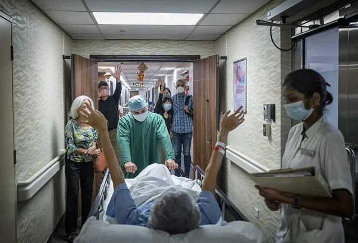 Ms Jill Alphonso being wheeled off into the operation theatre, with her close friends and family giving her their support. Photo: BRYAN VAN DER BEEK/WHAT ARE YOU DOING SG
