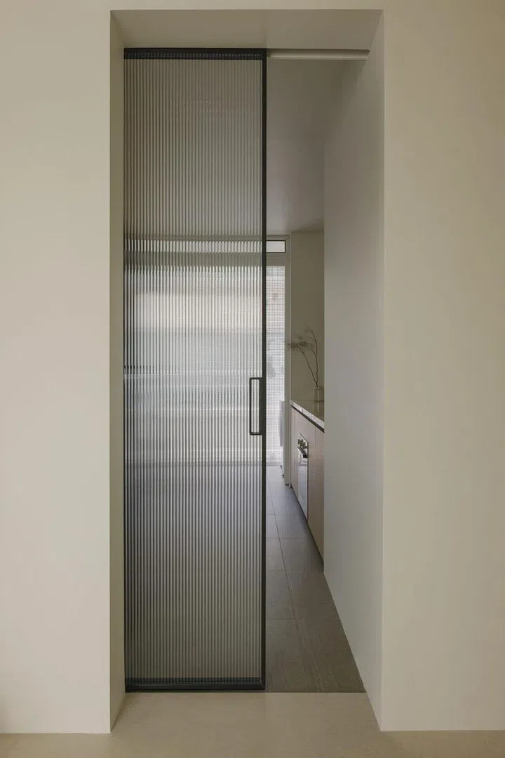 Glass sliding door creates an enclosed kitchen space in this private condominium apartment in Serangoon Gardens.Image Home & Decor