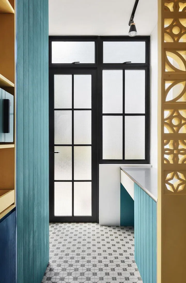 Framed frosted glass doors and vintage ventilation blocks in this 2-bedroom walk-up apartment along East Coast Road.
