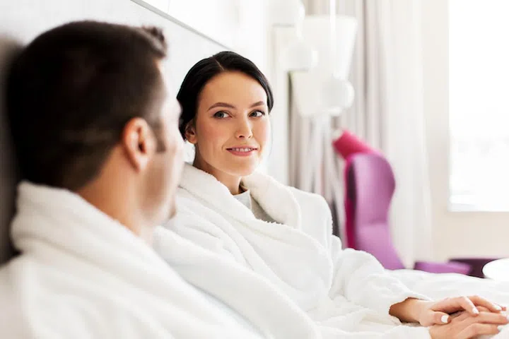 people, leisure and vacation concept - happy couple in bed at home or hotel room