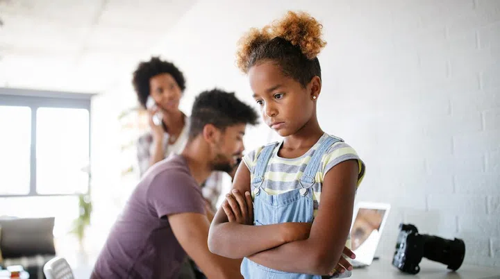 Frustrated angry sad child looking for attention from busy working parents