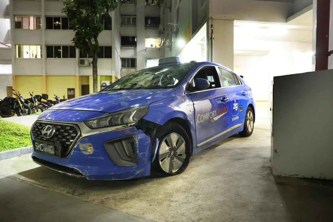 德士左前轮爆胎，保险杠也因撞到组屋墙壁而松脱。（蔡振鸿摄）