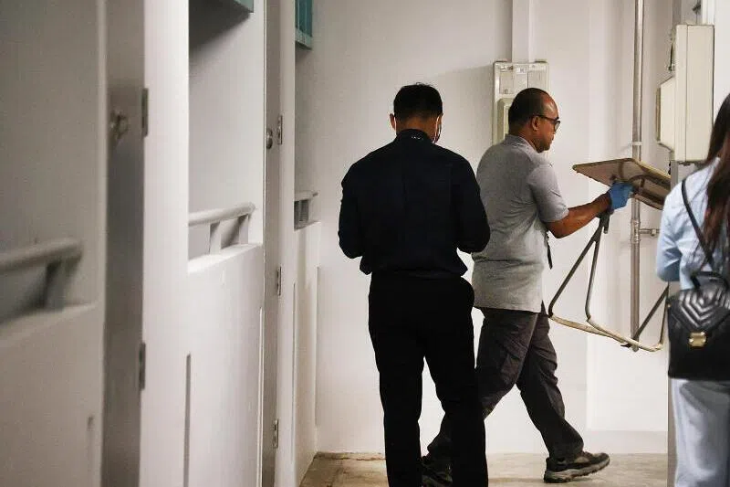 调查人员将摆放在走廊上的折叠桌带走。（蔡振鸿摄）