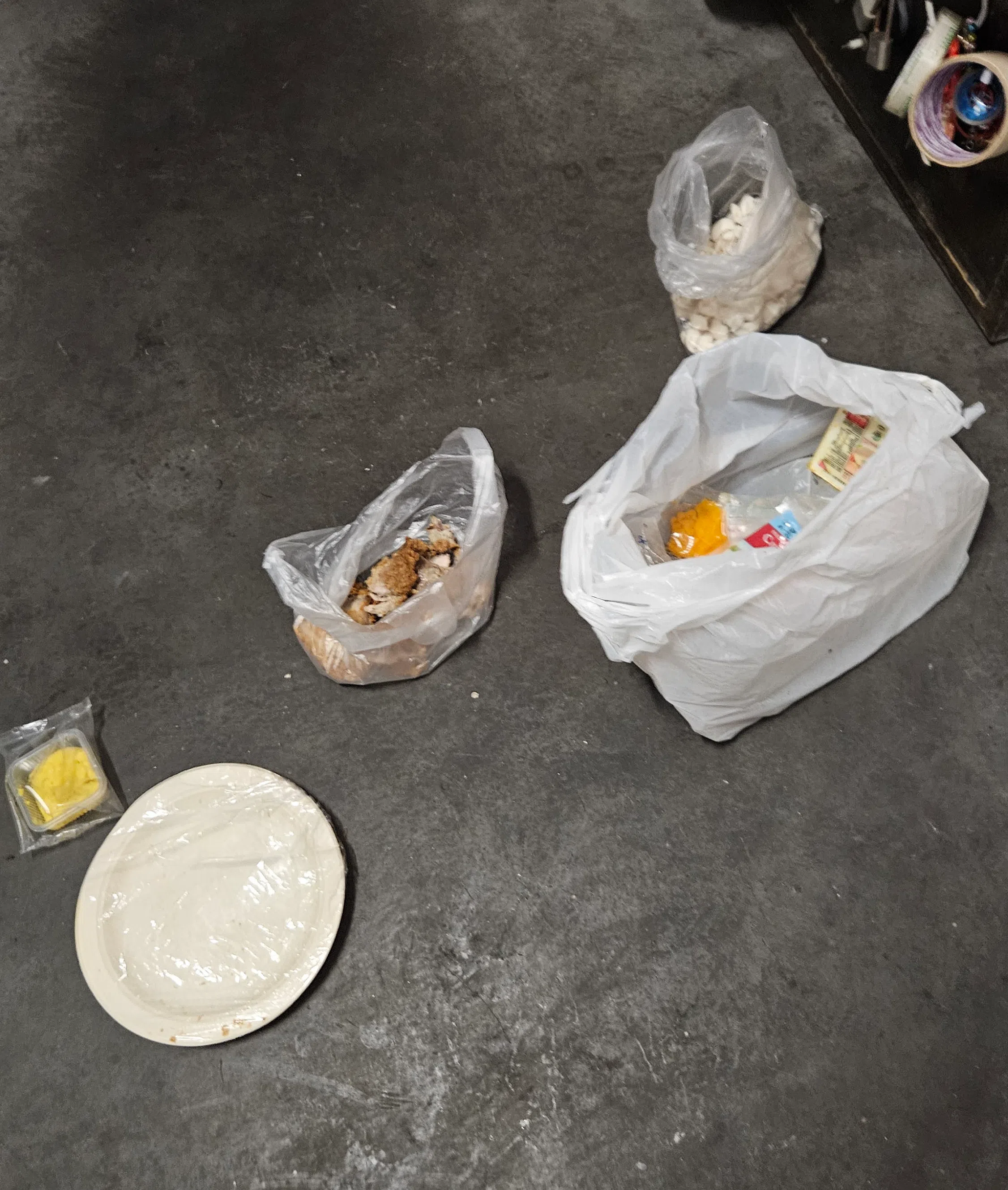 黄女士的家门前摆放着不少捡来的食物，供她自己和鸽子食用。（庄耿闻摄）