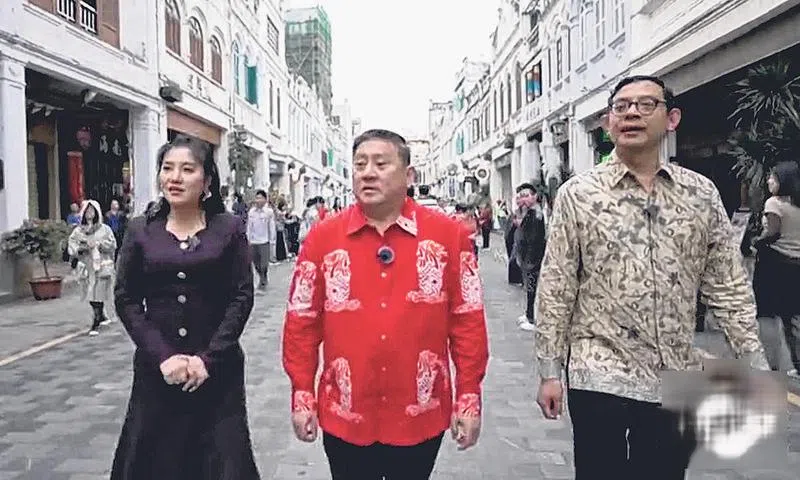 陈海泉（中）、罗德杰（右）在主持人的陪同下逛骑楼老街。（截自视频）