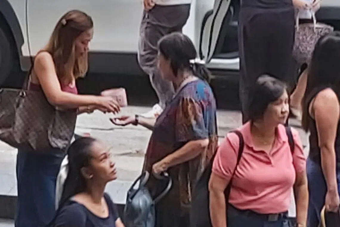 妇女穿着时髦，一身深色连衣裙向人讨钱。（受访者提供）