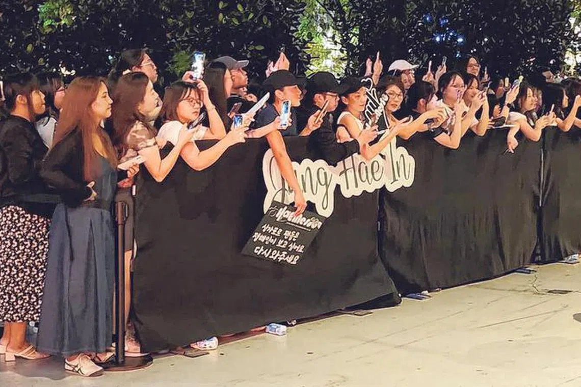 粉丝拿着应援牌等候丁海寅现身。（李琪雯摄）