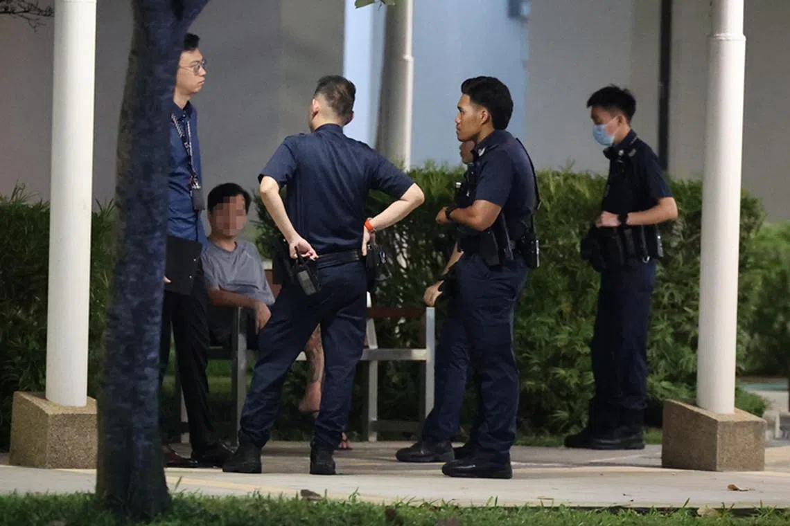  涉案男子在组屋楼下接受警员盘问。（刘启成摄）