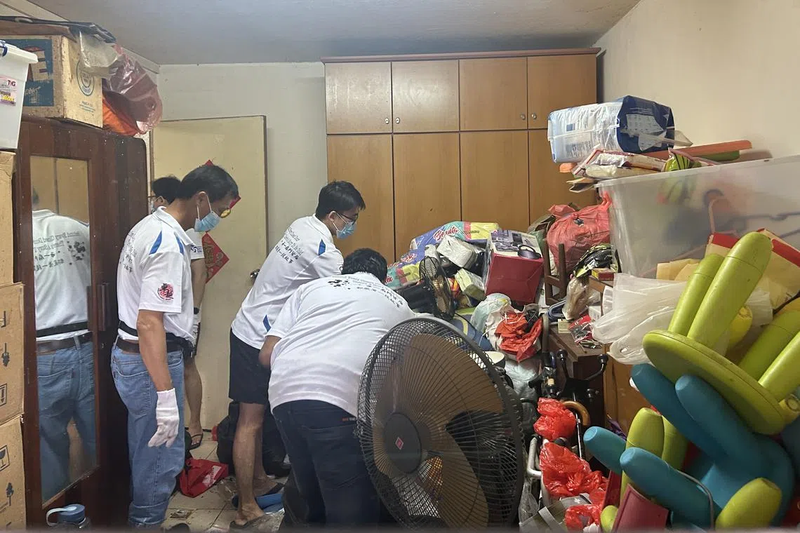 这间“垃圾屋”是二房式组屋单位，义工进入房间搬走堆积如山的家具与垃圾。（严思莹摄）