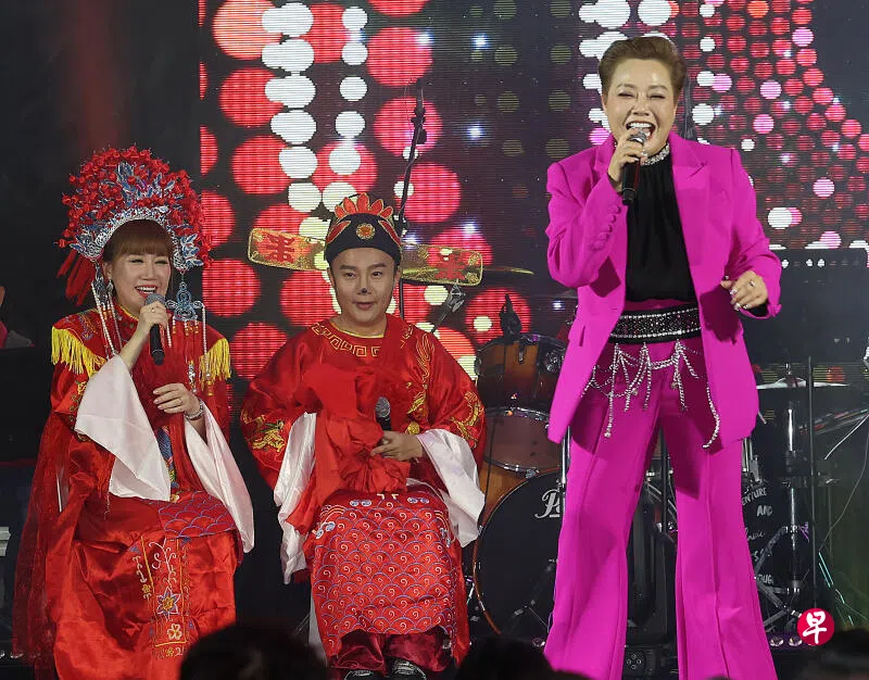 一对“新人”袁瑾（左）、皓皓坐在台上欣赏朱莉莉（右）演唱。 （蔡振鸿 摄）