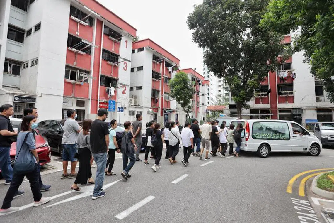 灵车驶向万礼，亲友鱼贯而行。