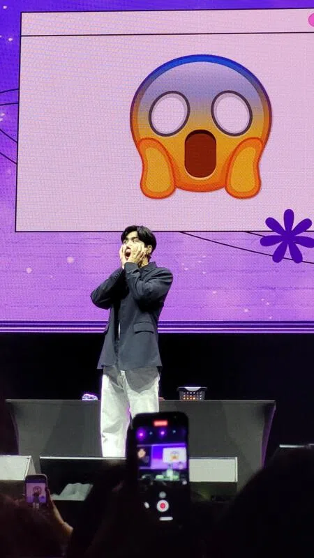 金宣虎玩游戏输了以后，跟着情感符号（emoji）做表情。（胡淑微摄）