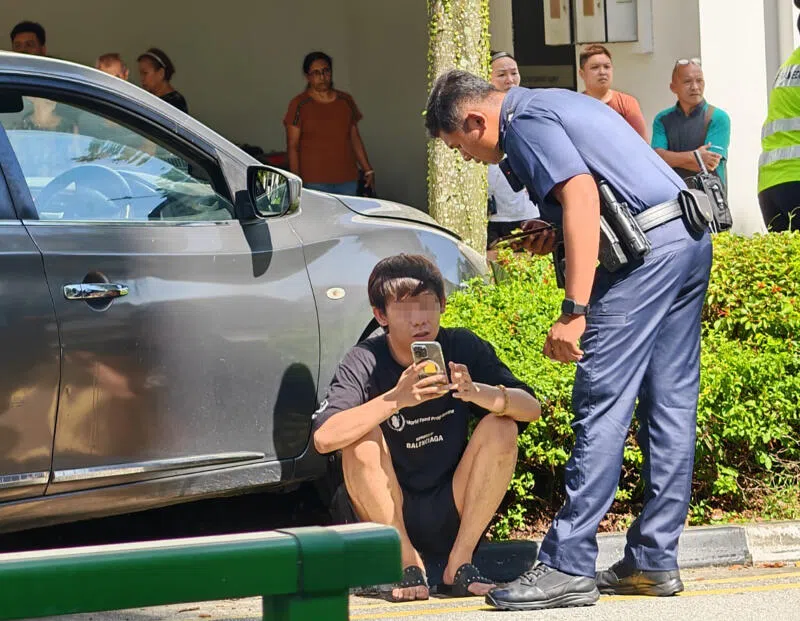 肇事男子下车后坐在一旁接受问话。（受访者提供）