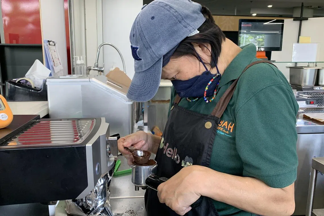 胡秀梅虽患有大脑麻痹症，但使用咖啡机难不倒她。（覃若兰摄）